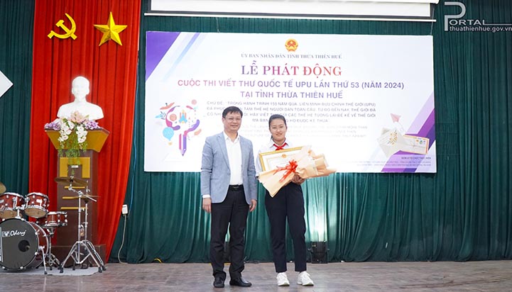 Phó Chủ tịch Thường trực UBND tỉnh Nguyễn Thanh Bình trao Bằng khen của UBND tỉnh cho em Nguyễn Vũ Thục Uyên