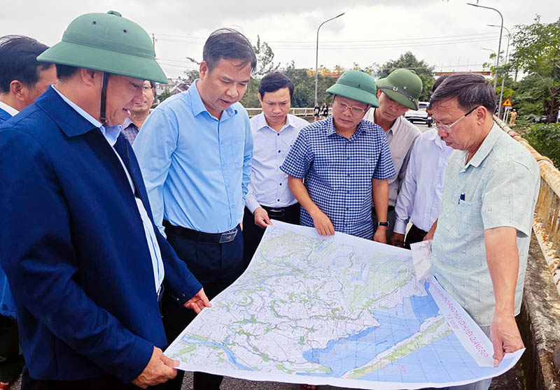 Phó Bí thư Thường trực Tỉnh ủy Phạm Đức Tiến nghe báo cáo về hệ thống thủy lợi thoát lũ trên địa bàn huyện.