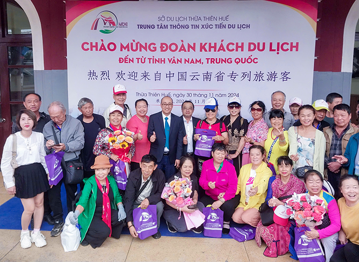 The representative of Tourism Department takes photo with foreign visitors travelling on trans-Vietnam charter train